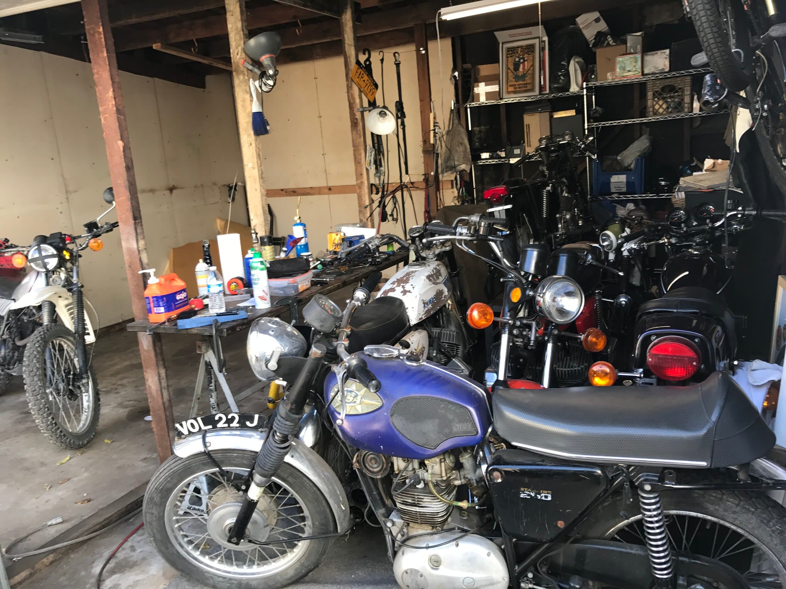 An image of the New York City Motorcycles garage in Venice, California. There are a lot of vintage motorbikes crowded in there; most notably a lovely old BSA motorcycle.