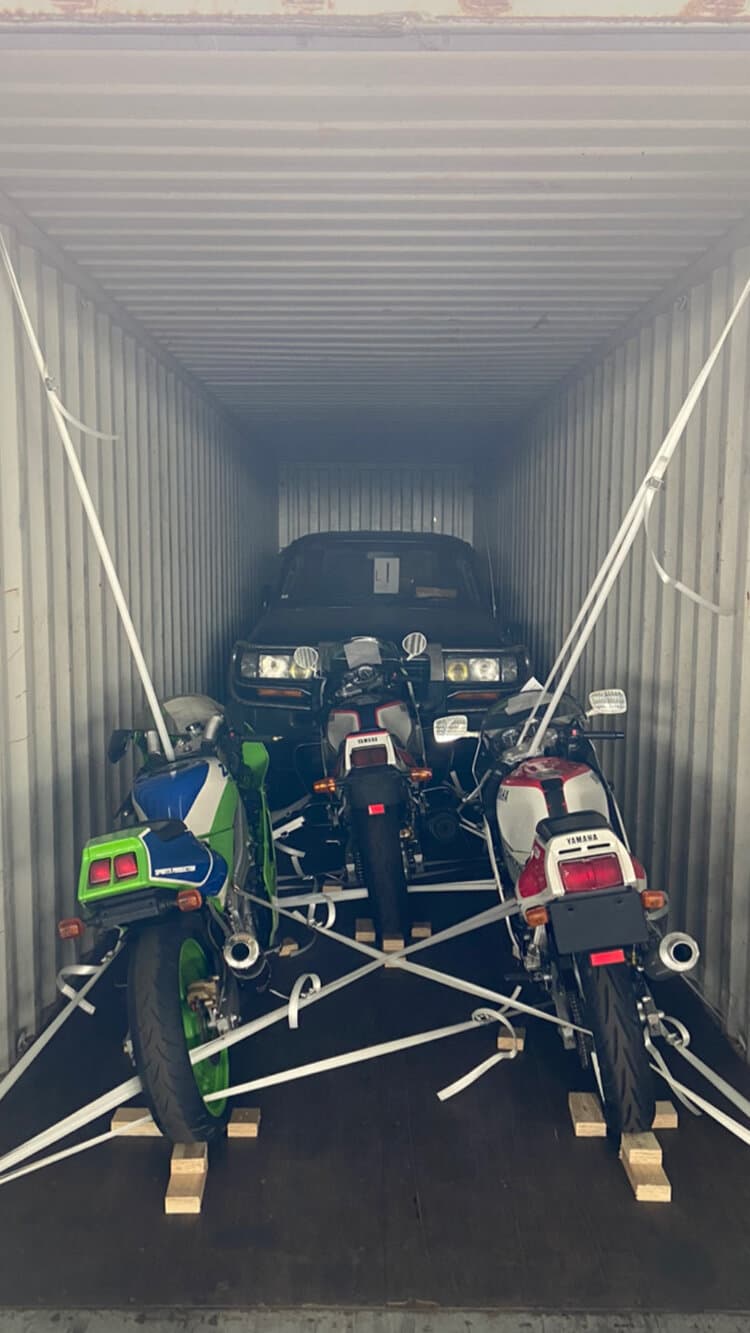 An image of a shipping container full of vintage cars and motorcycles on their way to Japan.