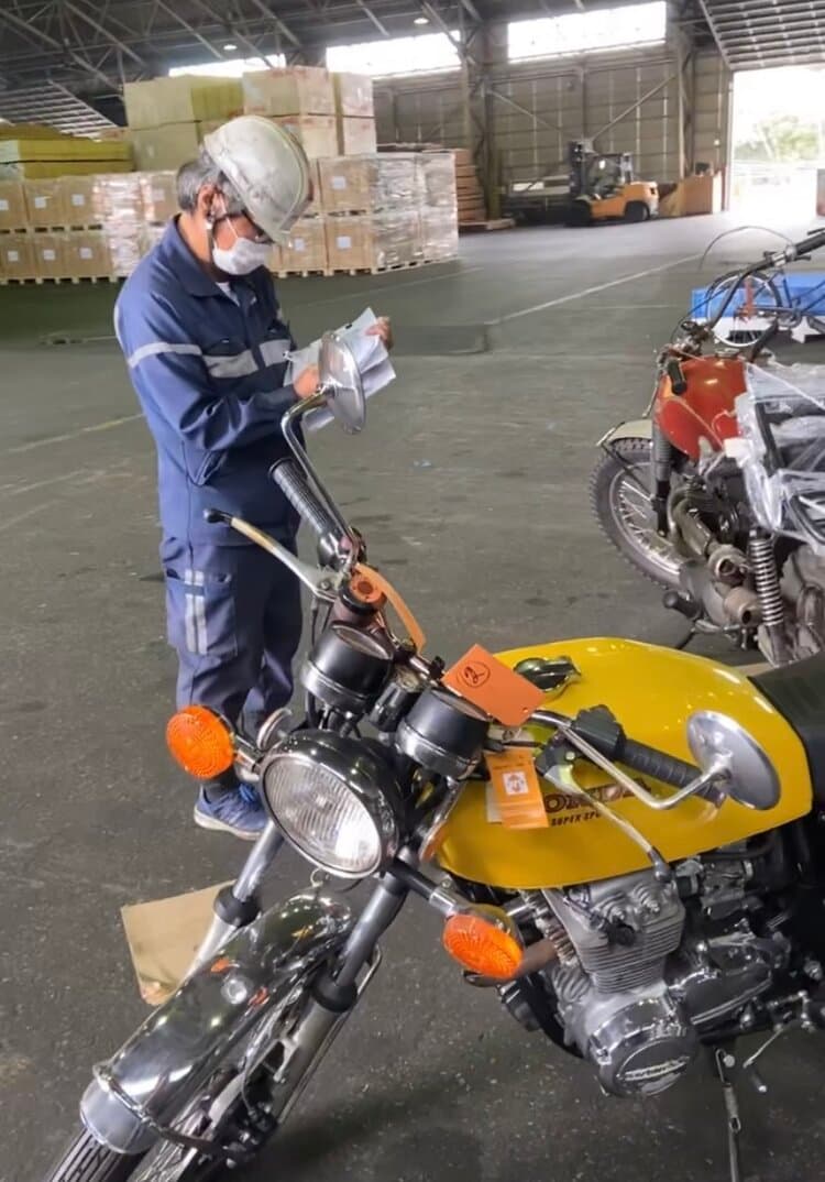 An image of a motorbike passing customs checks at a Japanese port.